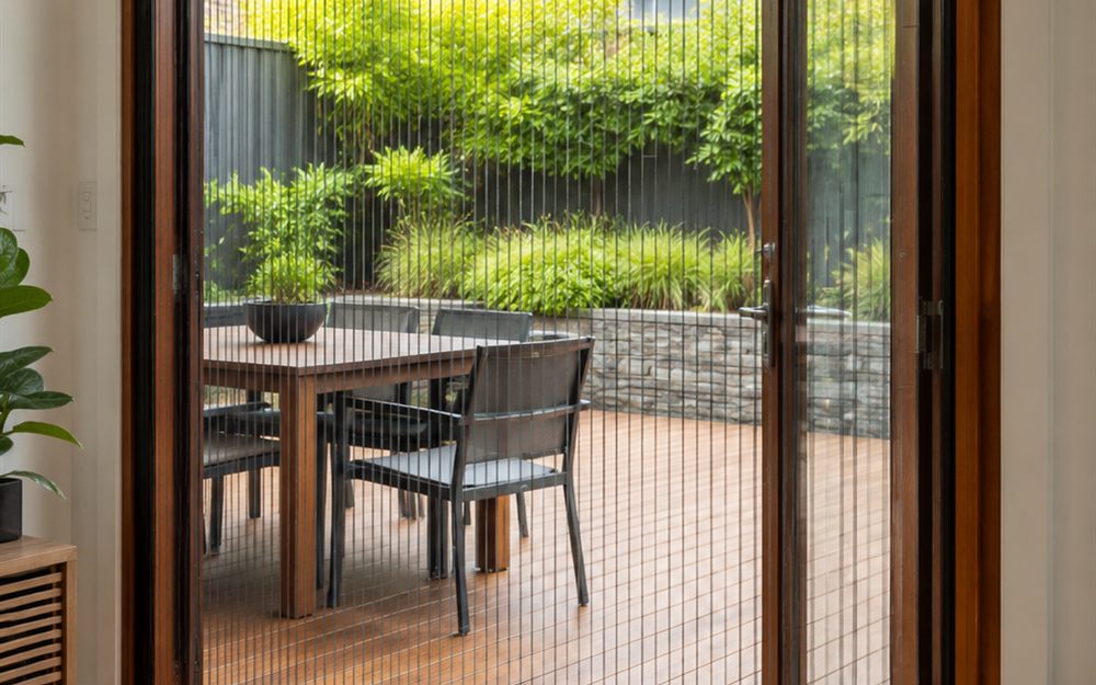 Retractable pleated flyscreen drawn across an open doorway